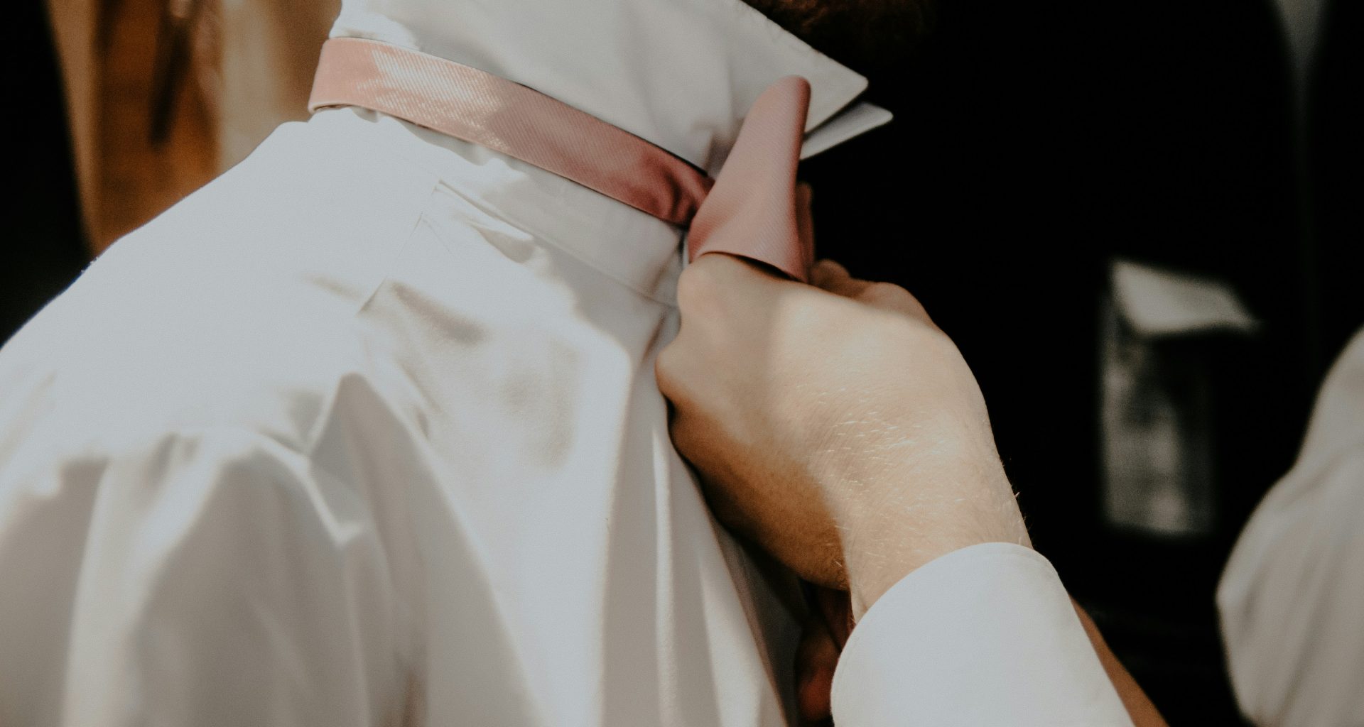 eine-nahaufnahme-einer-person-die-eine-krawatte-bindet-Pxr-bze5mrM