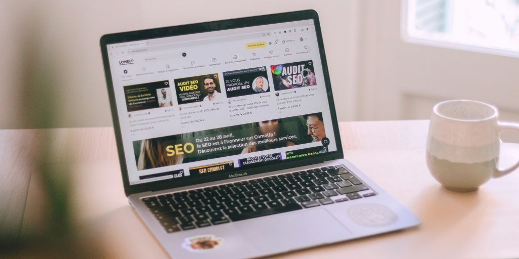 ein-laptop-der-auf-einem-holztisch-sitzt-TlUL9G-RUz4