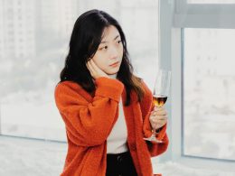 eine-frau-halt-ein-glas-wein-vor-einem-fenster-rdYPHtVbNTk