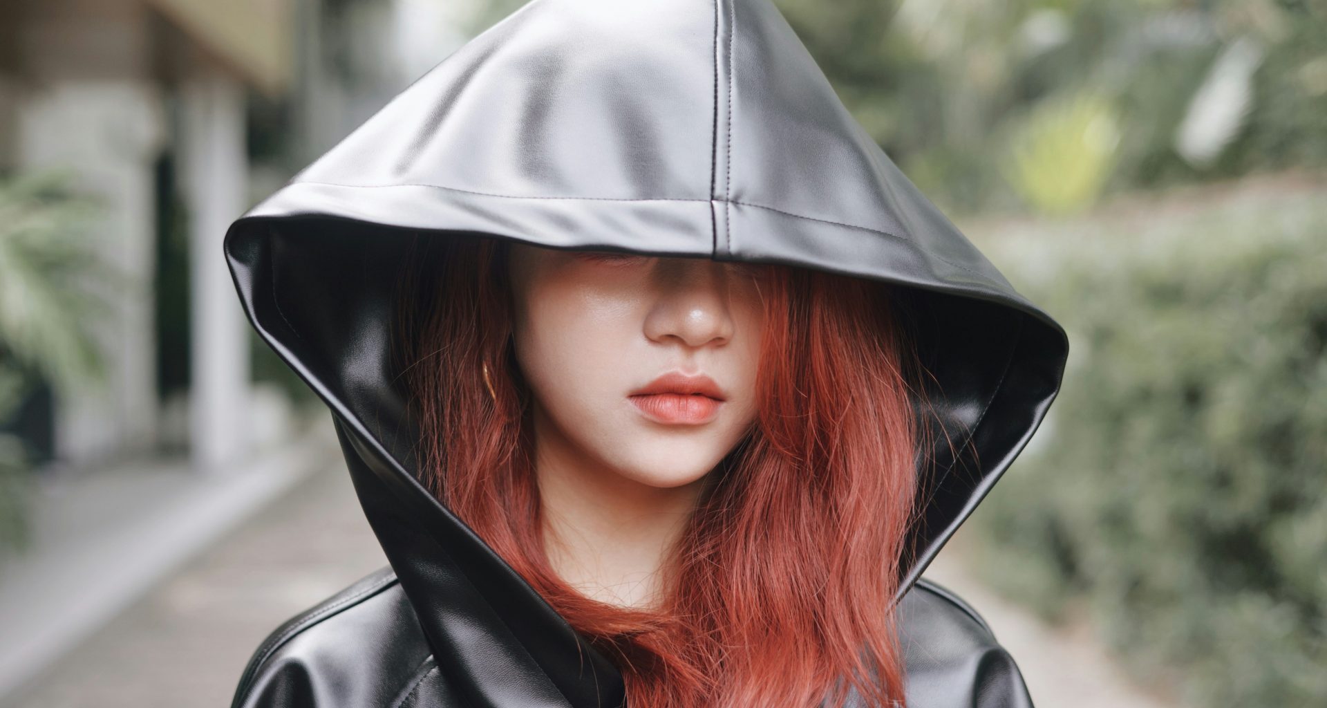 eine-frau-mit-roten-haaren-die-einen-schwarzen-lederkapuzenpulli-tragt-n6ZsYGtUFJs