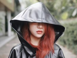 eine-frau-mit-roten-haaren-die-einen-schwarzen-lederkapuzenpulli-tragt-n6ZsYGtUFJs