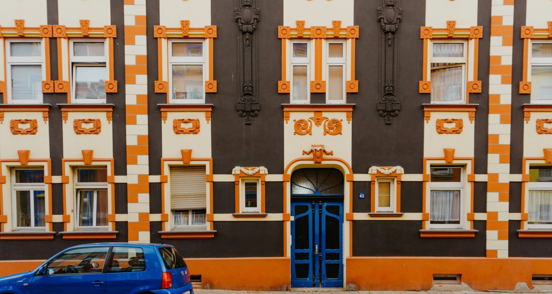 blaues-auto-vor-dem-gebaude-geparkt-NxWdBnFiikg