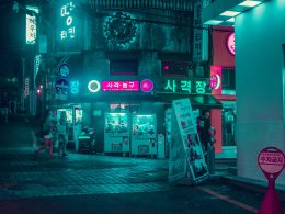 gruppe-von-menschen-die-nachts-auf-der-strasse-in-der-nahe-von-gebauden-gehen-rHvBQyfLPjk