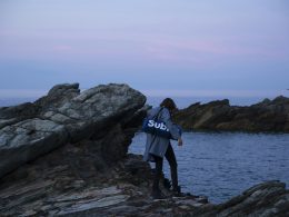 person-die-tasche-tragt-die-auf-einem-felsen-steht-sW_kKXX3H-Y