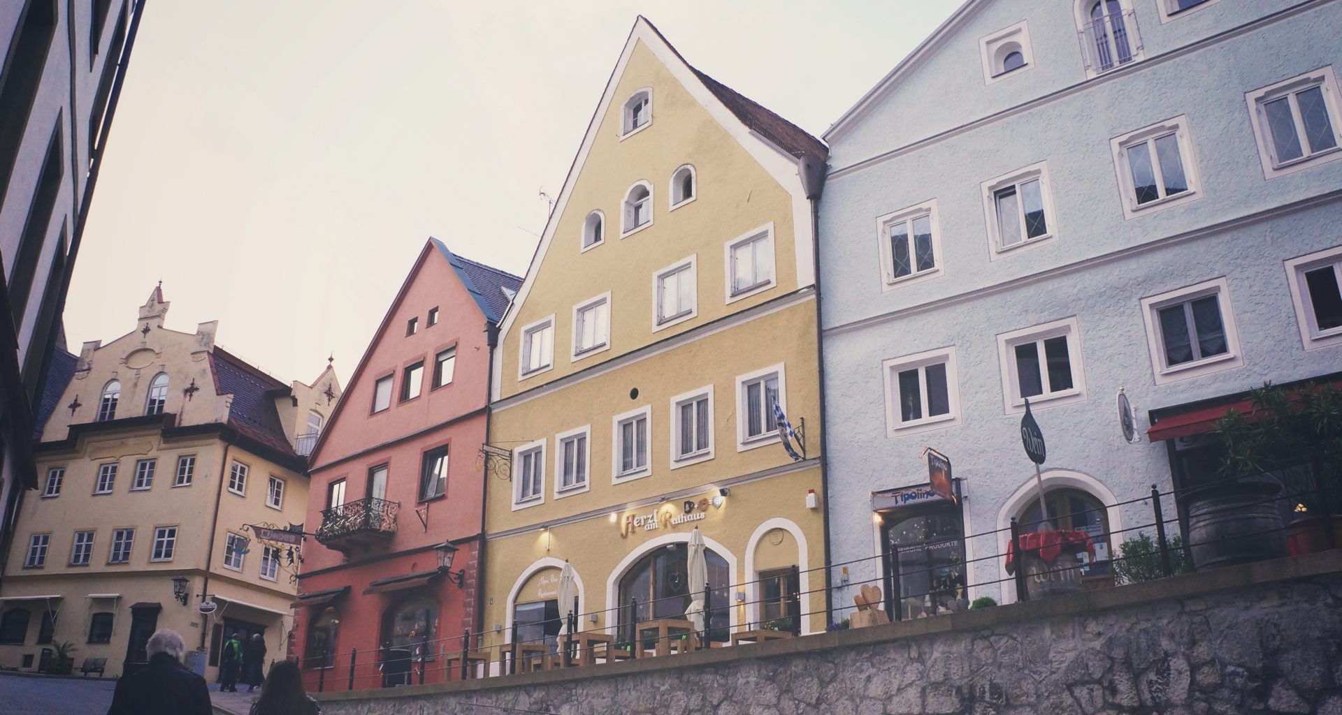 drei-verschiedenfarbige-dreieckige-dachhauser-neben-der-strasse-Iz3ep6k9teA