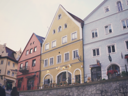 drei-verschiedenfarbige-dreieckige-dachhauser-neben-der-strasse-Iz3ep6k9teA