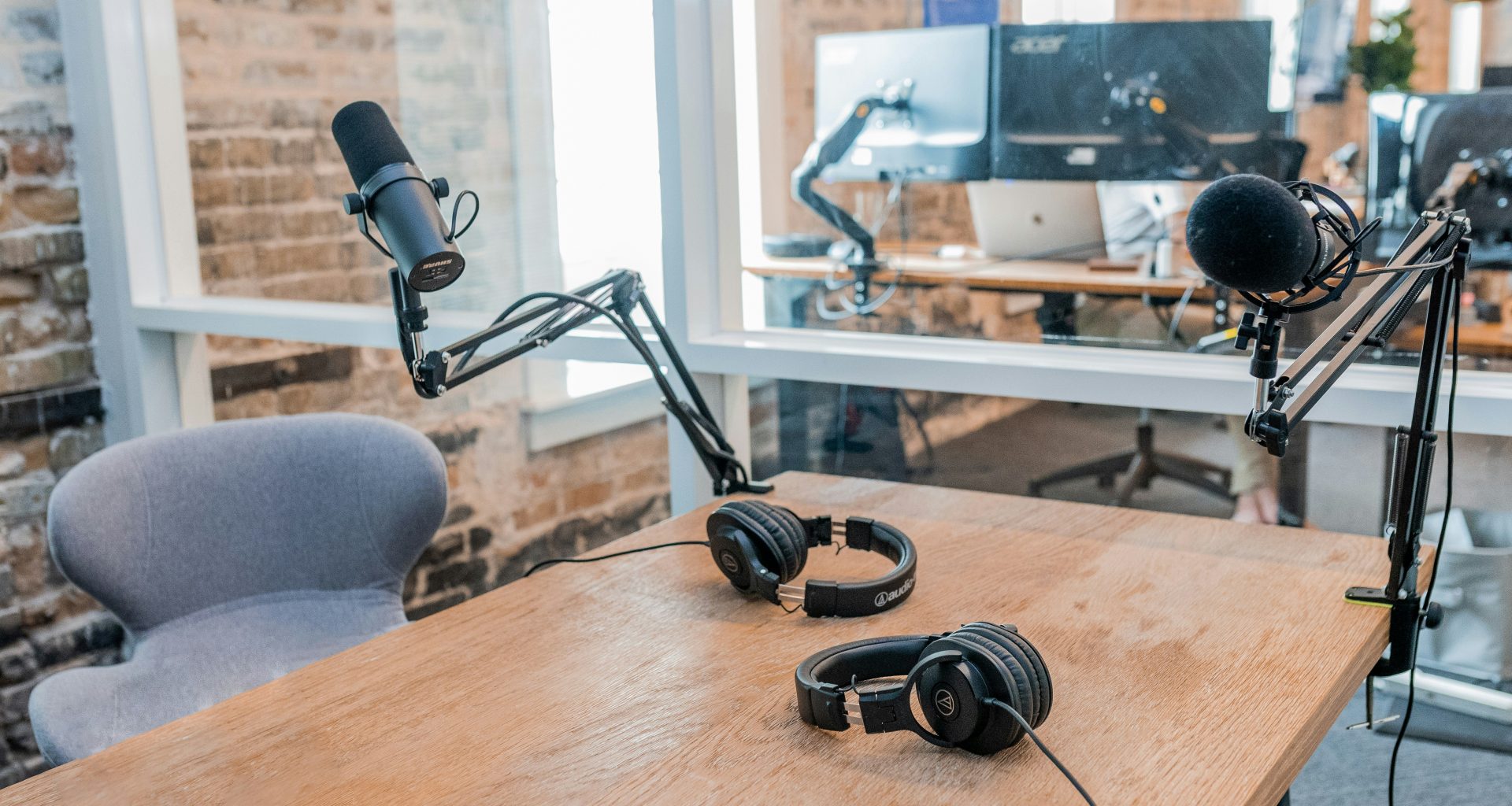 zwei-schwarze-kopfhorer-auf-braunem-holztisch-VCFxt2yT1eQ