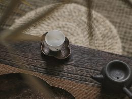 weisse-teetasse-auf-untertasse-in-der-nahe-der-teekanne-cmWUcVSJWOw