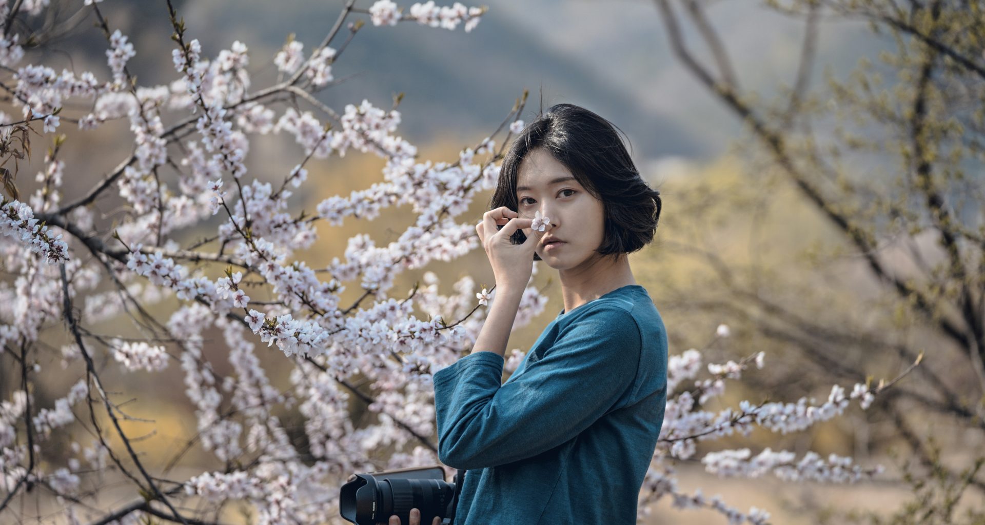 frau-die-kirschbluten-wahrend-des-tages-riecht-xX9r2xULy7s