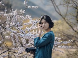 frau-die-kirschbluten-wahrend-des-tages-riecht-xX9r2xULy7s