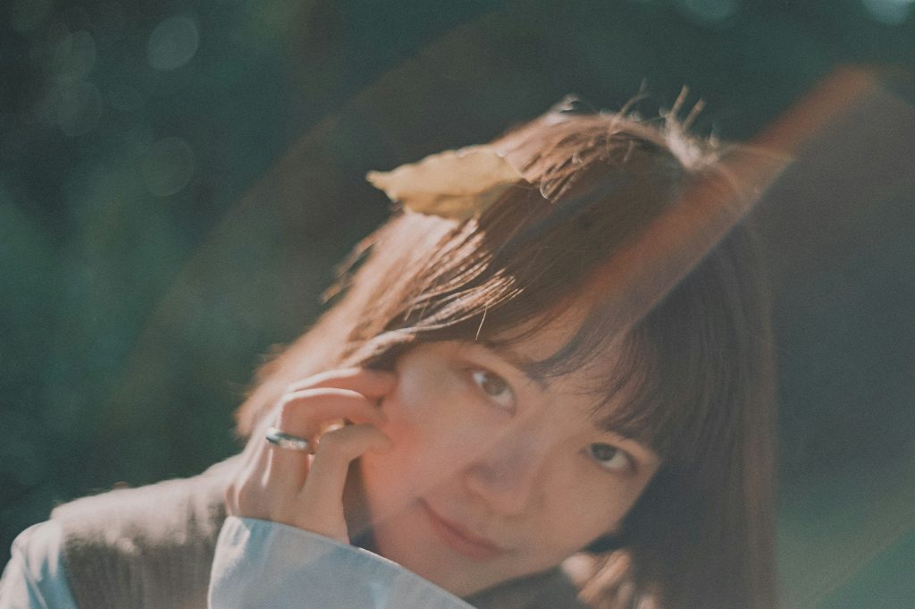 frau-tragt-braun-weisses-oberteil-und-lachelt-sWqby3lFxd0