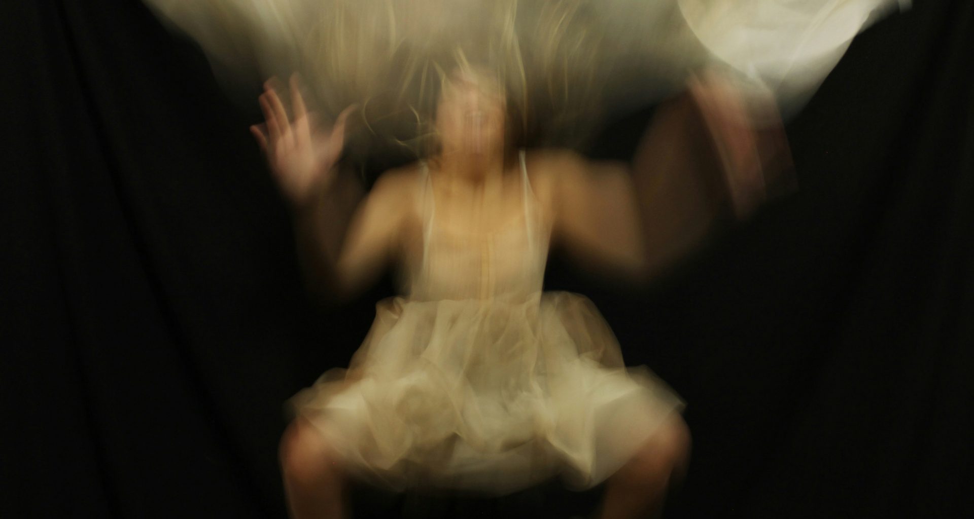 ein-verschwommenes-foto-einer-frau-die-auf-einem-stuhl-sitzt-DW8G-Oc8V3I