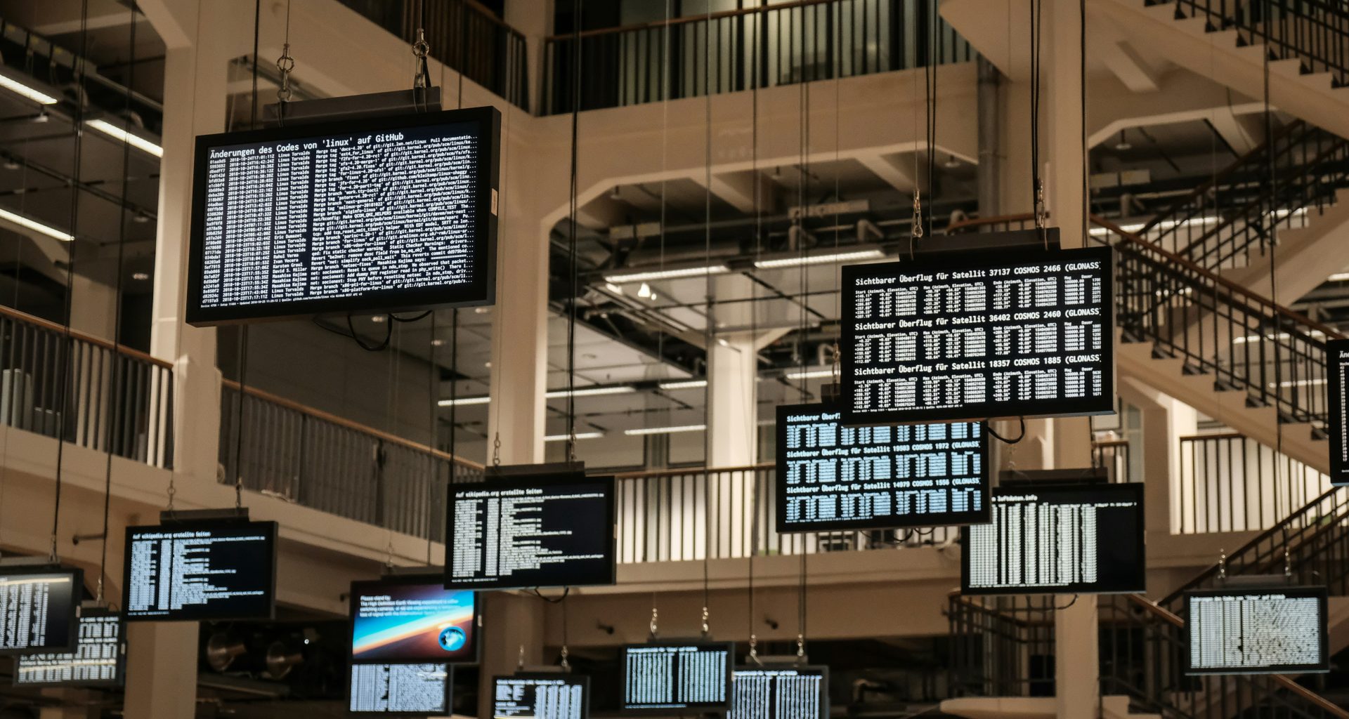 ein-haufen-fernsehbildschirme-die-von-der-decke-hangen-iM8dxccK1sY