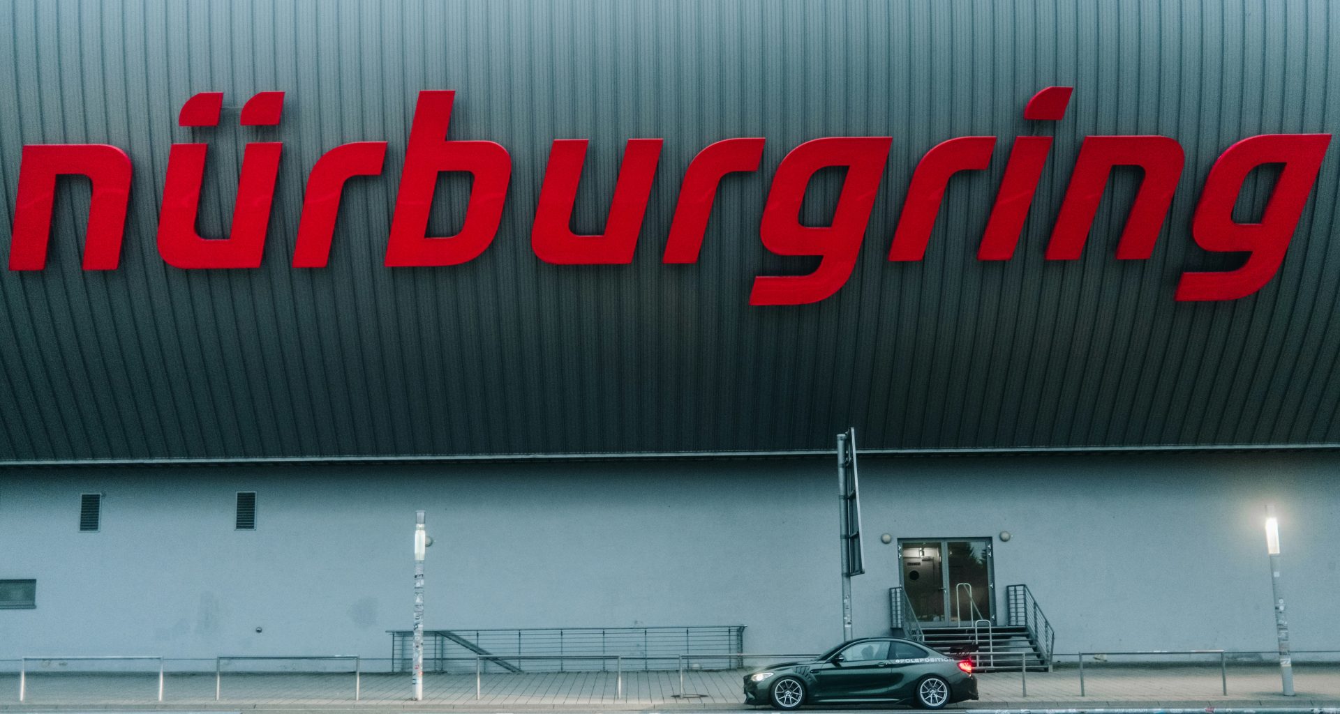 ein-auto-das-vor-einem-grossen-gebaude-geparkt-ist-iu-x4H5LROk