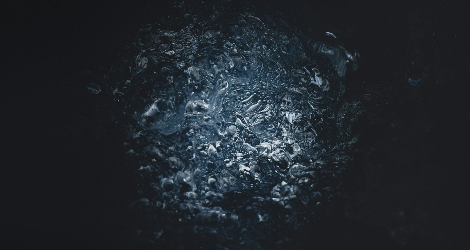 eine-nahaufnahme-einer-schwarzen-oberflache-mit-wasser-HSo-6tRqpTM