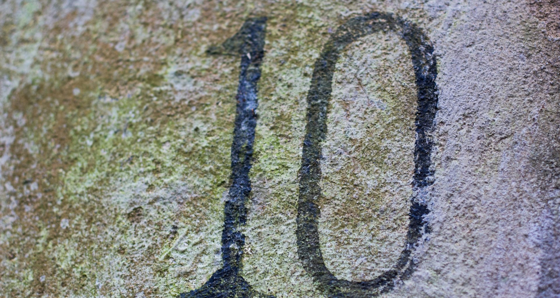 eine-nahaufnahme-einer-zahl-auf-einem-felsen-vbQsU3kVVPI