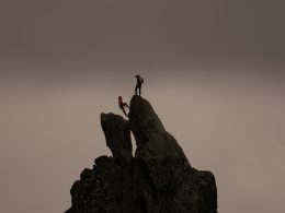 ein-paar-leute-klettern-auf-einen-felsen-jXjq7_Z-fpQ