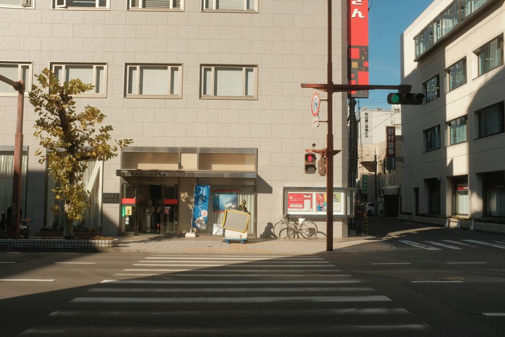 ein-zebrastreifen-vor-einem-gebaude-an-einem-sonnigen-tag-vcckIvIz4YE