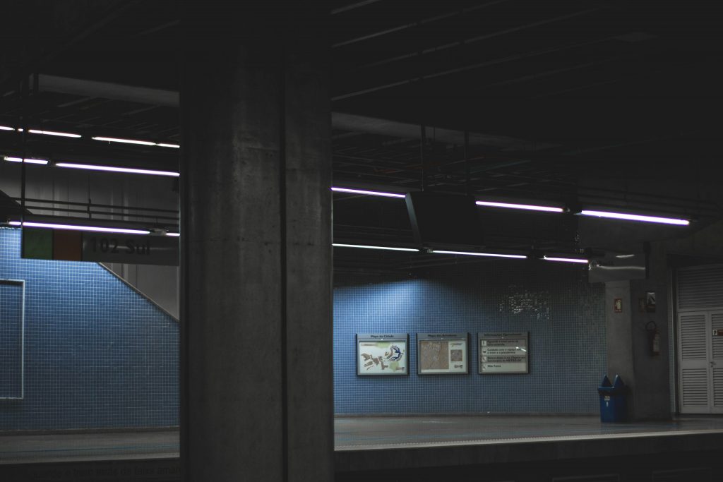 ein-dunkler-raum-mit-einer-blauen-wand-und-einer-uhr-an-der-wand-o47Lif2bfqI