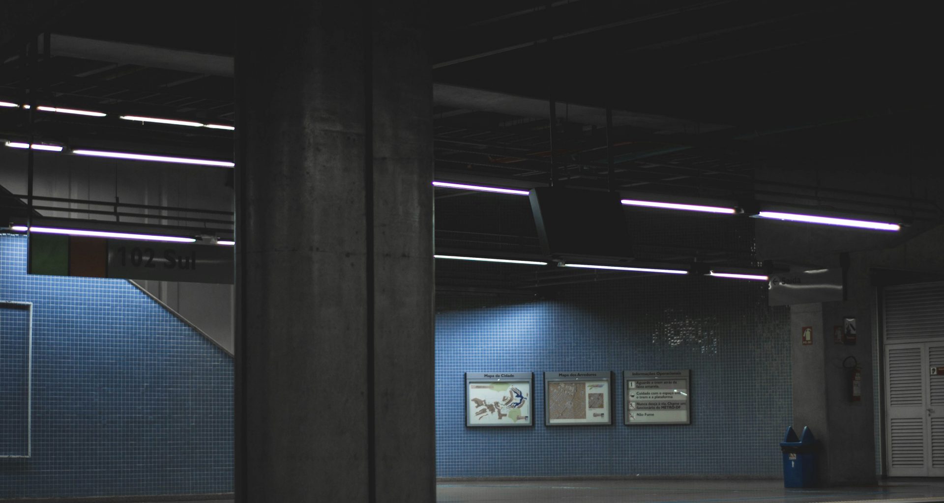 ein-dunkler-raum-mit-einer-blauen-wand-und-einer-uhr-an-der-wand-o47Lif2bfqI