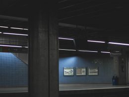 ein-dunkler-raum-mit-einer-blauen-wand-und-einer-uhr-an-der-wand-o47Lif2bfqI