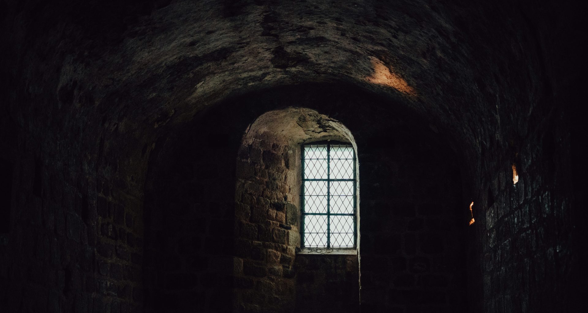 ein-dunkler-tunnel-mit-einem-fenster-darin-Etgz5hsyPCk