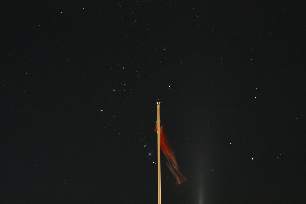 eine-flagge-an-einer-stange-am-nachthimmel-js7_wK0mPJY