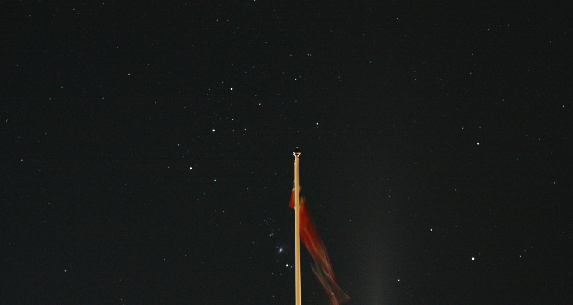 eine-flagge-an-einer-stange-am-nachthimmel-js7_wK0mPJY