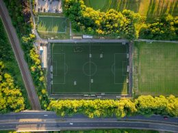 ein-grunes-gebaude-mit-einem-schild-umgeben-von-baumen-TgAOYzHDfMc