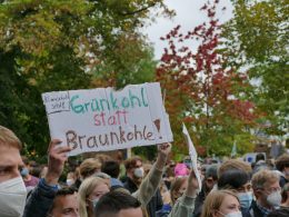 eine-gruppe-von-menschen-die-schilder-halten-und-masken-tragen-OaJUK1l-fW4