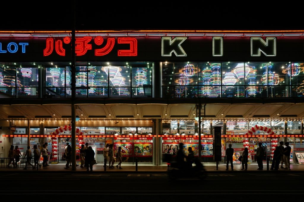eine-gruppe-von-menschen-die-nachts-vor-einem-geschaft-stehen-iB2hbc0soDM