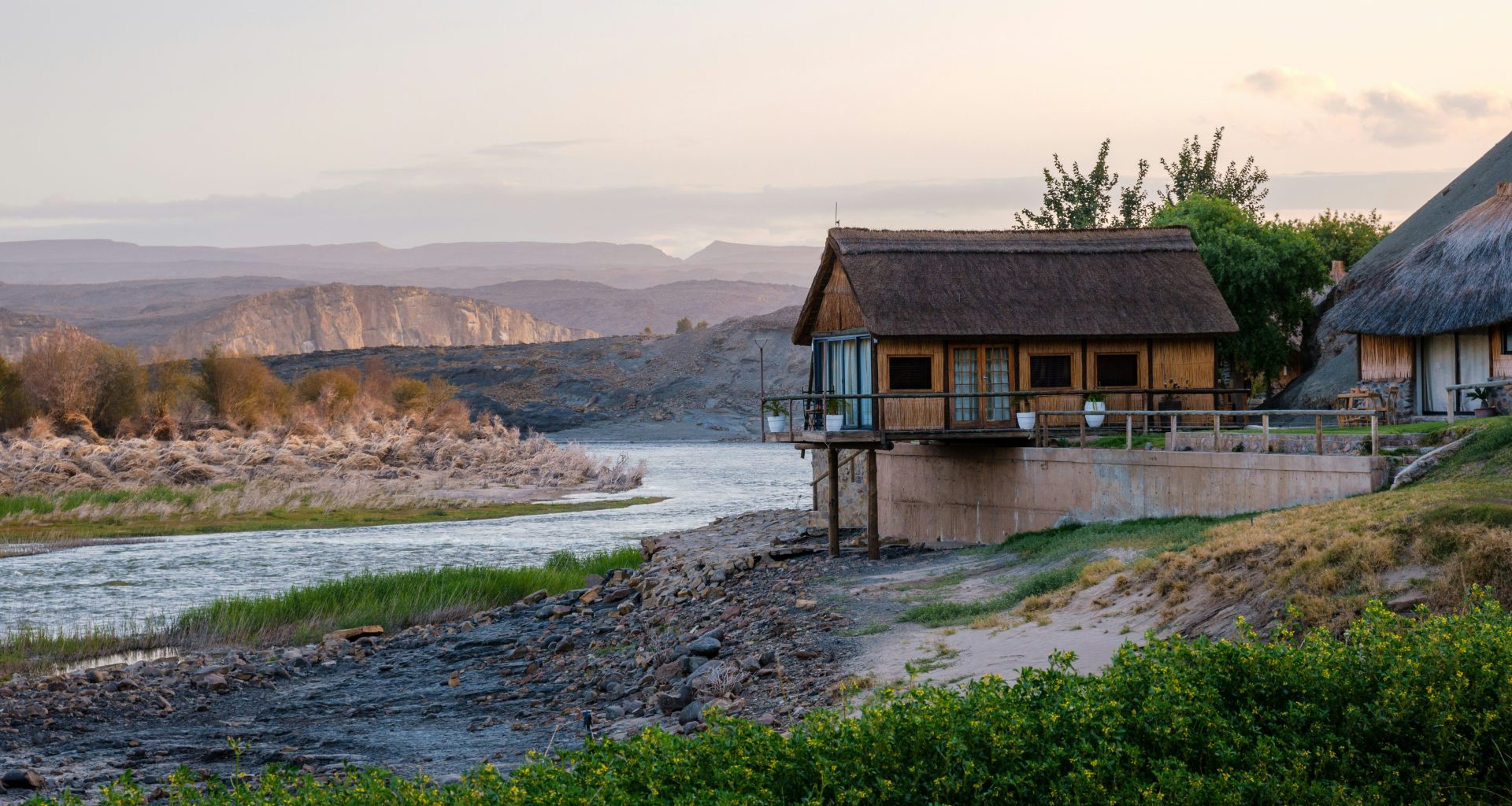 ein-haus-auf-einem-hugel-an-einem-fluss-cadAk-7nTc8