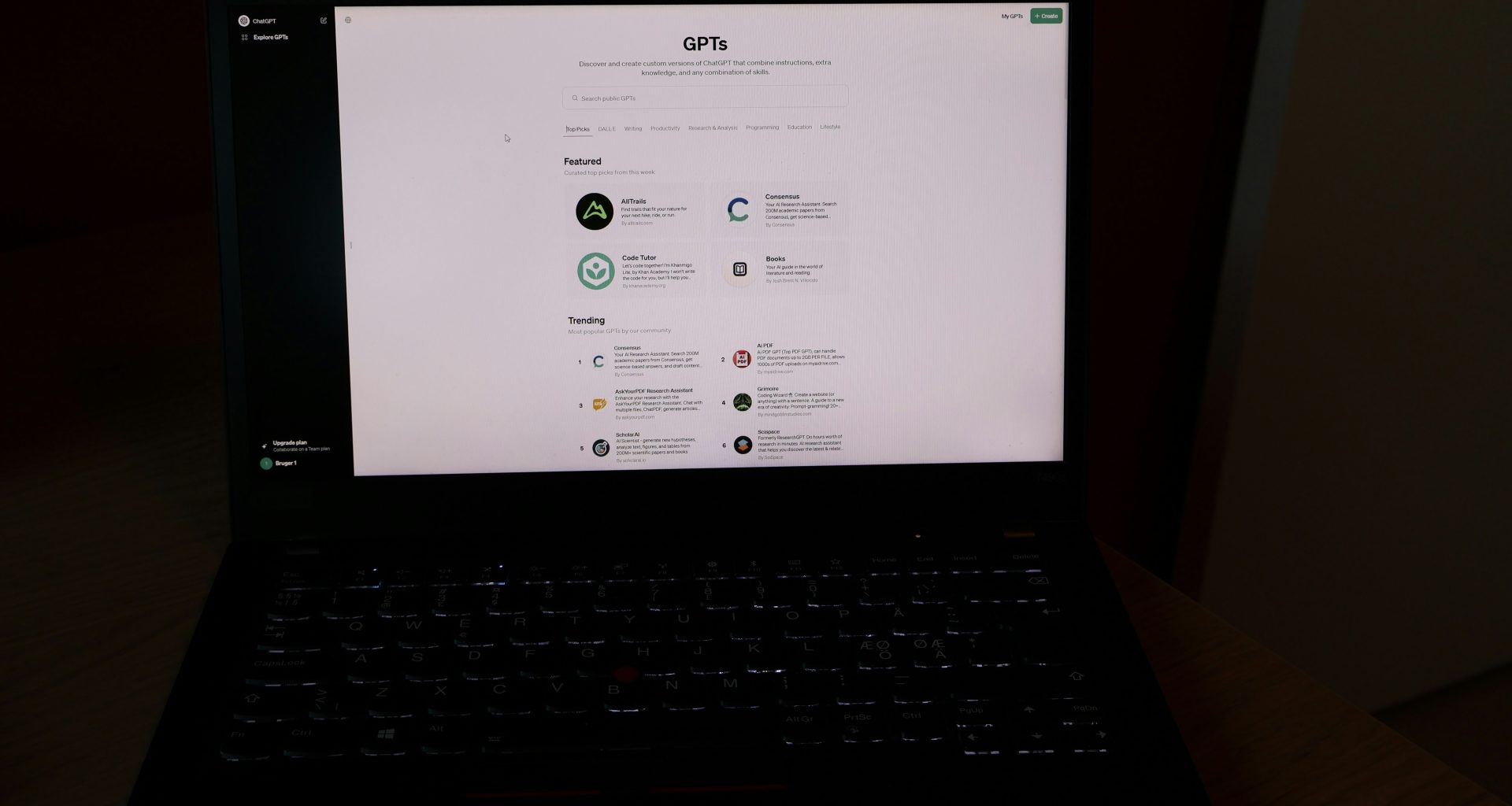 ein-laptop-der-auf-einem-holztisch-steht-FSYciNwhrSI