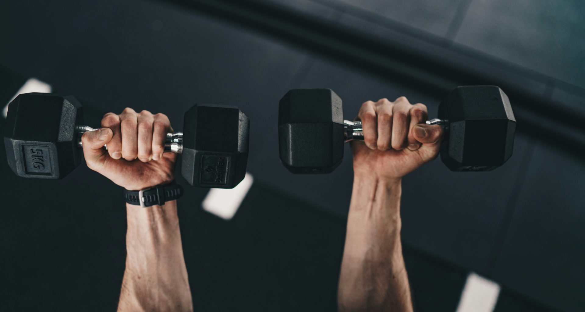 ein-mann-der-zwei-dummkopfe-in-einem-fitnessstudio-hebt-WH-RyVhNEes