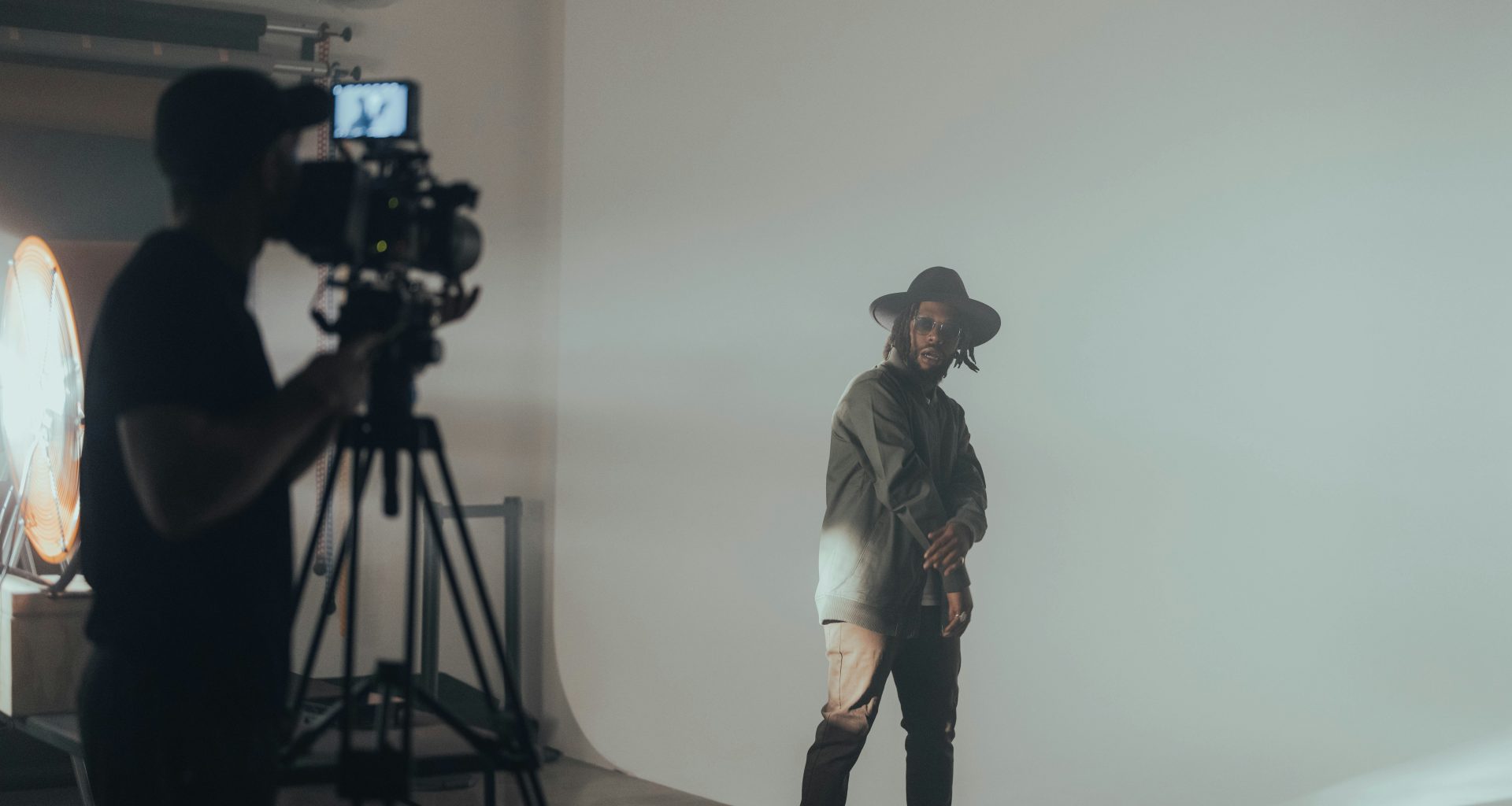 ein-mann-steht-vor-einer-weissen-wand-lqfpl0OSjFQ