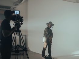 ein-mann-steht-vor-einer-weissen-wand-lqfpl0OSjFQ