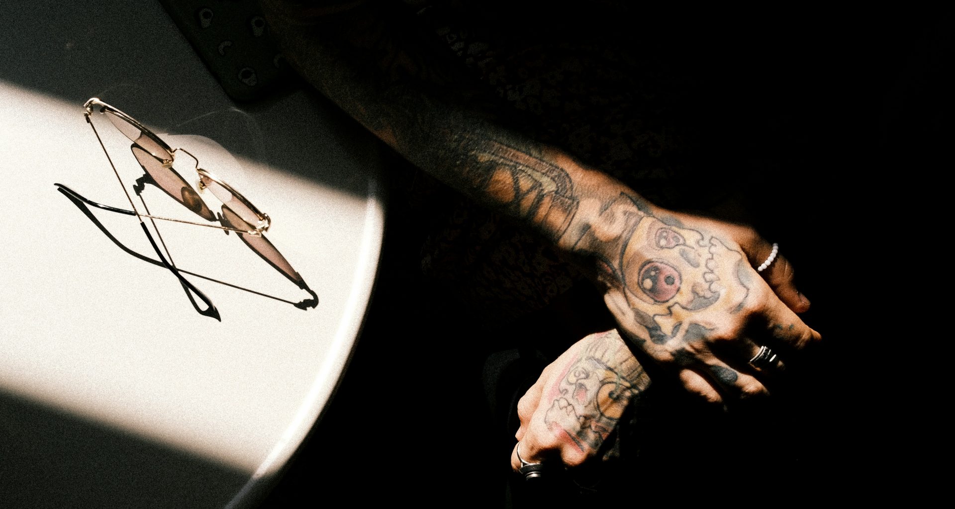 ein-mann-mit-tattoos-auf-dem-arm-neben-einem-tisch-kqDvRQa0JRI