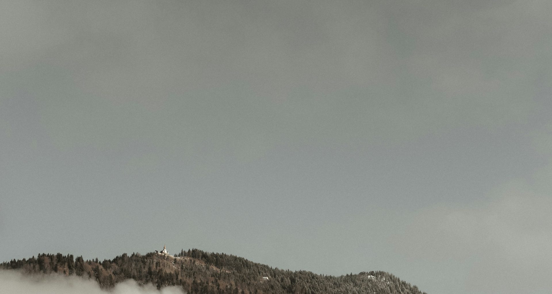 ein-in-nebel-und-wolken-gehullter-berg-unter-einem-bewolkten-himmel-ivSnqkc21MA
