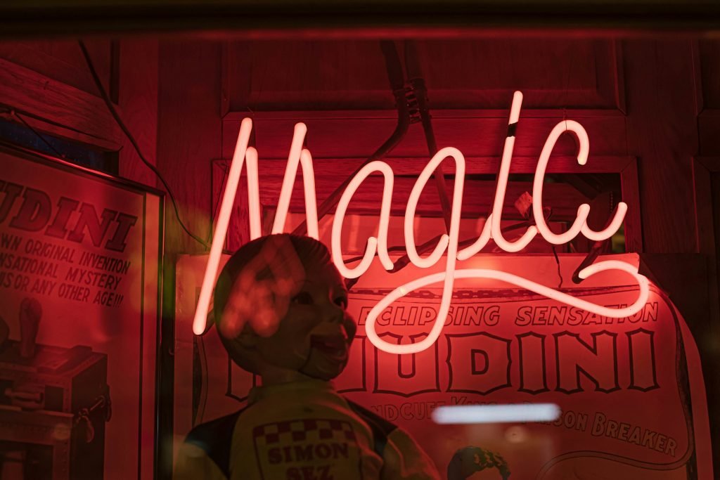 eine-leuchtreklame-auf-der-hinter-einer-schaufensterpuppe-magie-steht-Syp0k0-JkPQ