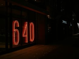 eine-leuchtreklame-mit-der-aufschrift-sechzig-an-der-seite-eines-gebaudes-HX7zpOs2ePM