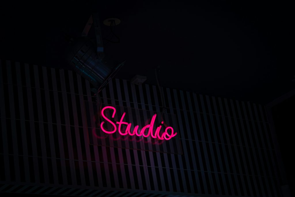 eine-leuchtreklame-mit-der-aufschrift-studio-an-der-seite-eines-gebaudes-FaYZbfPeqVE