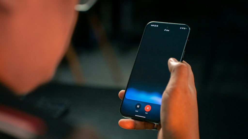 eine-person-die-ein-handy-in-der-hand-halt-4V1O9NzCZBE