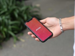 eine-person-die-ein-rotes-handy-in-der-hand-halt-sKRavSCadwE