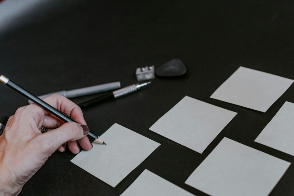 eine-person-zeichnet-quadrate-auf-einen-tisch-_bi1wILDT88