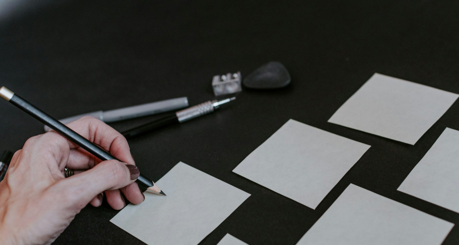 eine-person-zeichnet-quadrate-auf-einen-tisch-_bi1wILDT88