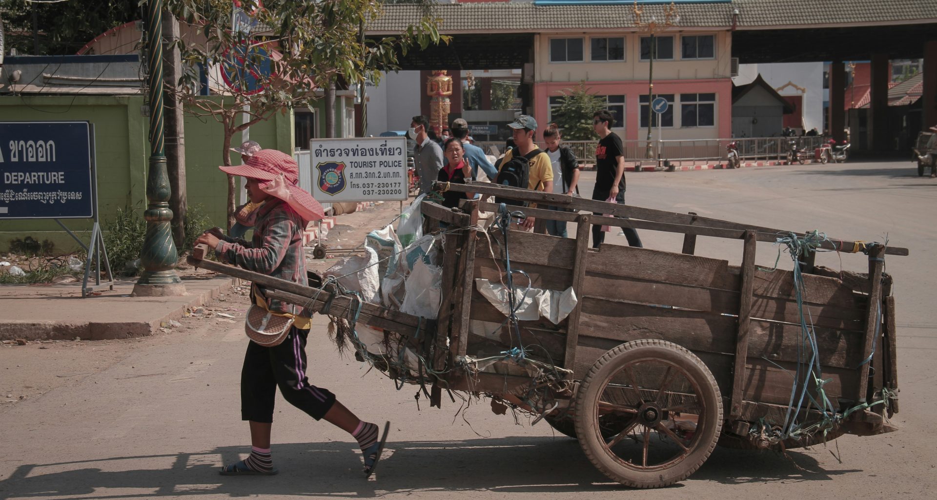 eine-person-die-einen-wagen-mit-einem-haufen-gegenstande-darauf-schiebt-w5fSxiBOCt0