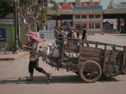 eine-person-die-einen-wagen-mit-einem-haufen-gegenstande-darauf-schiebt-w5fSxiBOCt0