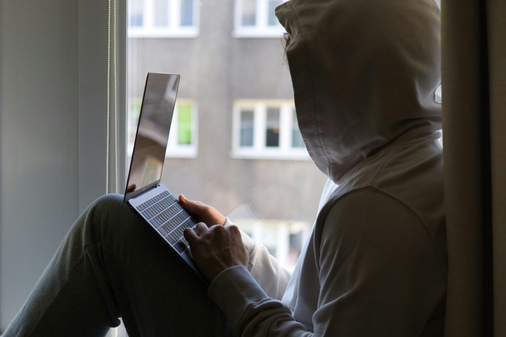 eine-person-die-mit-einem-laptop-auf-einer-fensterbank-sitzt-LUkBIQ2nwvg