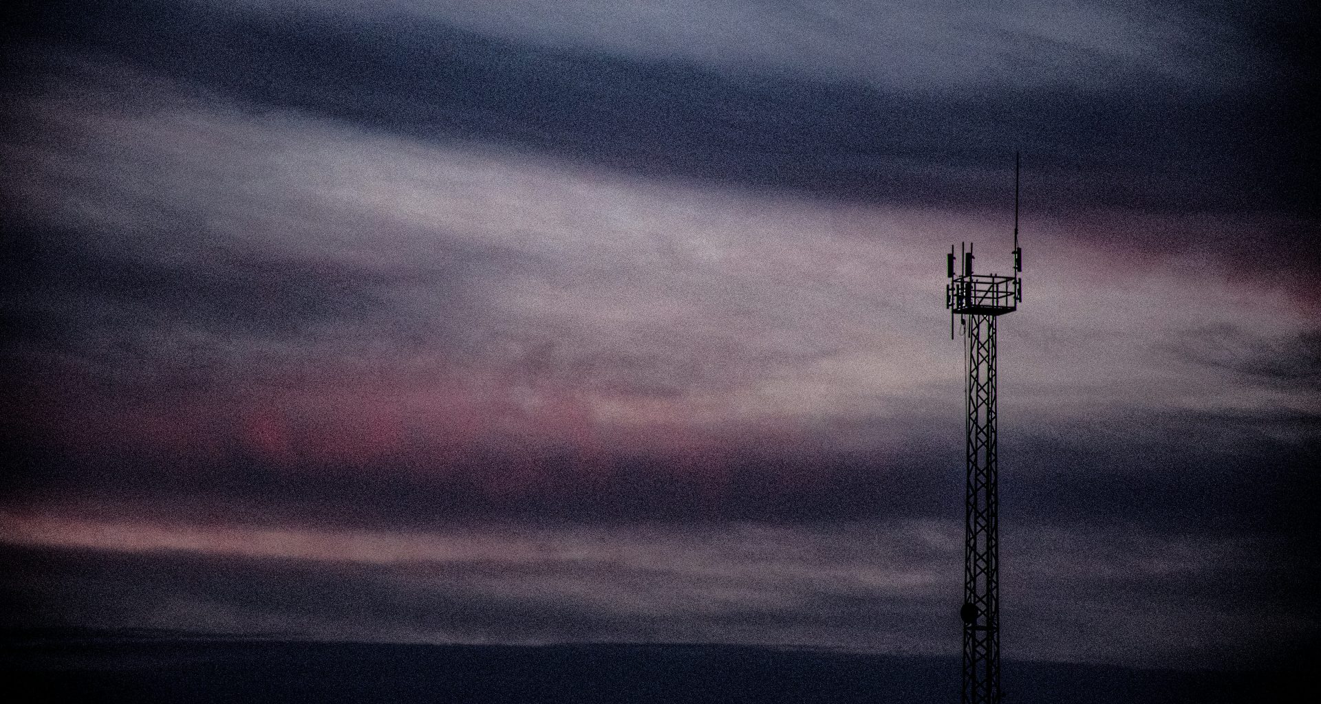ein-funkturm-streckt-sich-in-richtung-eines-stimmungsvollen-sonnenuntergangs-50cRMz6M-KA