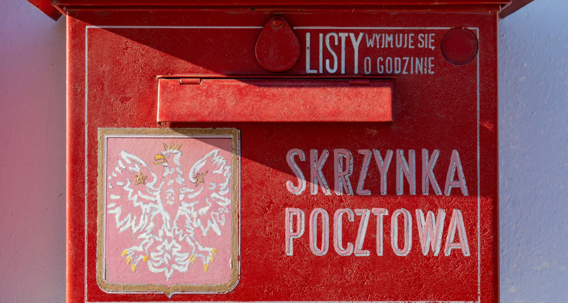 ein-roter-briefkasten-mit-dem-bild-eines-vogels-darauf-FmGwo93ExOc